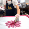 Motif floral en cours de peinture sur un carré de soie personnalisé lors d’un atelier à Lyon