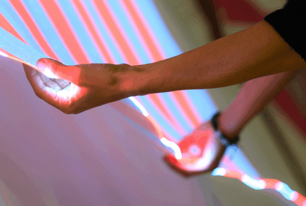 Détail d'une oeuvre lumineuse de l’artiste Daniel Buren exposée au musée Brochier Soieries à Lyon, mettant en valeur le dialogue entre art contemporain et textile