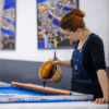 Imprimeur déposant la couleur sur un cadre d’impression pour réaliser un motif sur la soie selon la technique traditionnelle lyonnaise